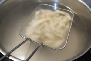 Fresh tagliatelle being boiled in salted water