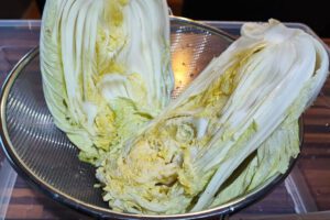 Nach 24 Stunden den Kohl spülen und abtropfen lassen: Spüle den gesalzenen Kohl nun gründlich und mehrfach unter kaltem, fließendem Wasser ab, um das gesamte überschüssige Salz zu entfernen. Dies ist entscheidend, um ein zu salziges Kimchi zu vermeiden. Lasse den Kohl anschließend in einem Sieb für 30-60 Minuten gut abtropfen, bis kein Wasser mehr heraustropft.