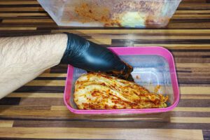 Eingerollte Chinakohl-Viertel dicht in das Fermentationsgefäß schichten